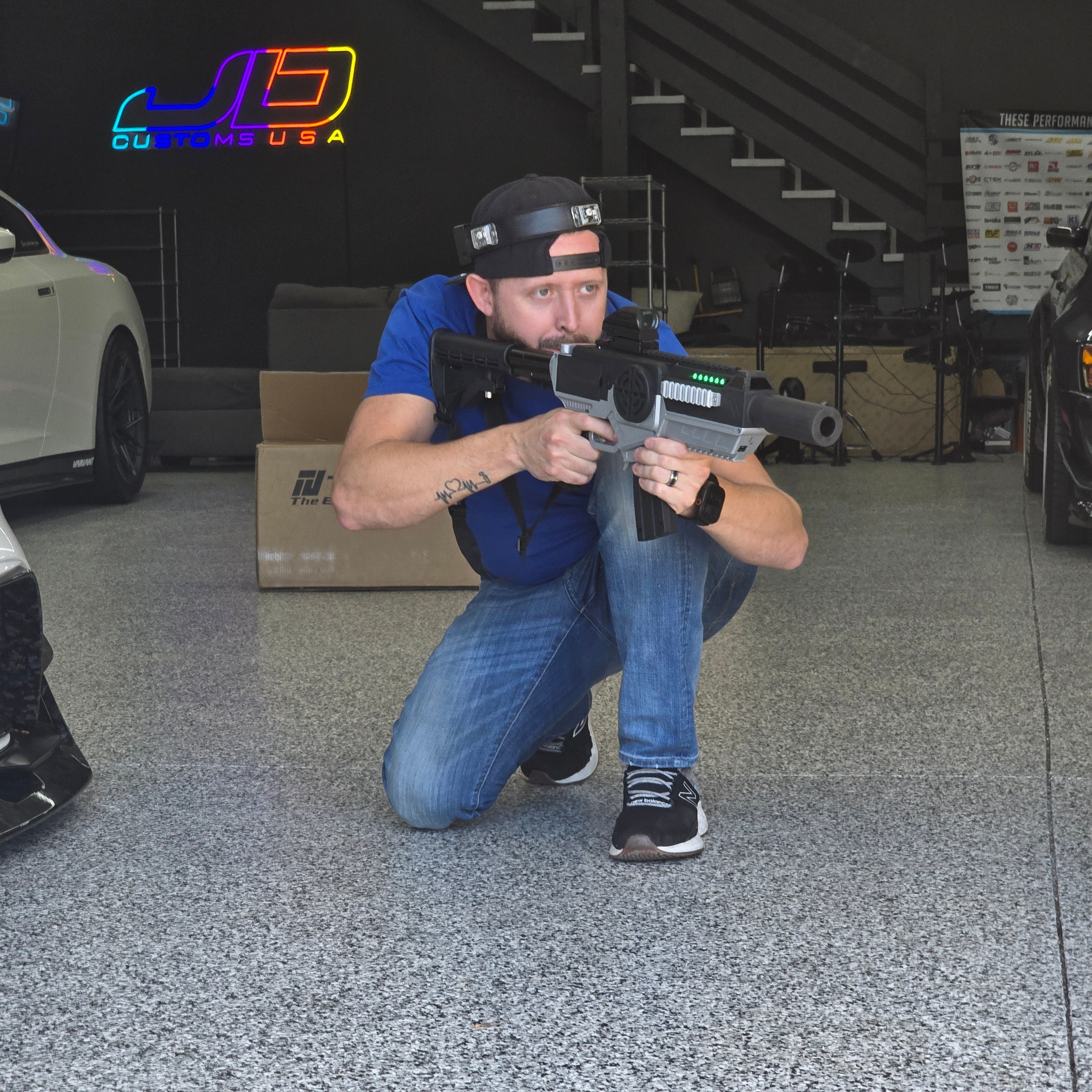 Jon of JD Customs USA in battle pose with a laser tag gun at his Chattanooga shop during a corporate team building event with Orbis Sports USA